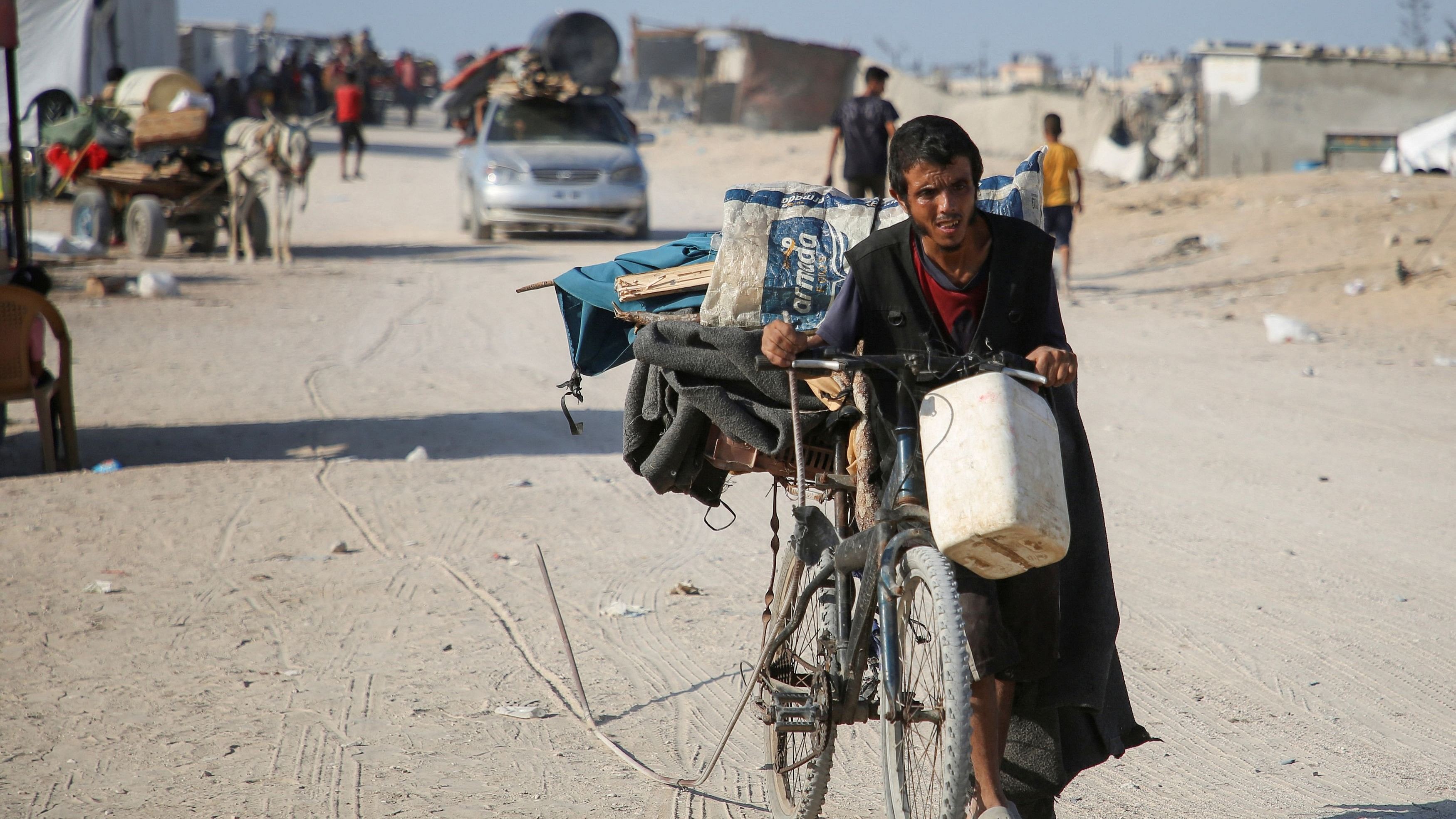 <div class="paragraphs"><p>Displaced Palestinians make their way, as they flee Hamad City following an Israeli evacuation order, in Khan Younis.</p></div>